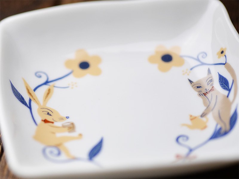 美濃焼製の白い小皿に雑貨デザイナーシンジカトウさんが猫とうさぎのイラストを描いた小皿のをデザインが分かるようにデザイン部分を大きく拡大した画像です。