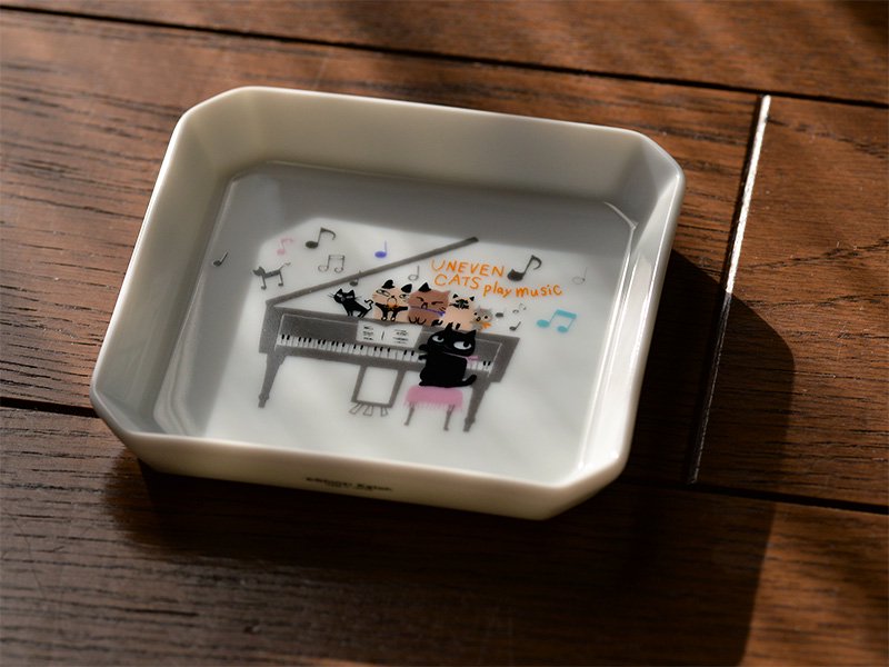 shinzikatoh シンジカトウデザイン　ピアノを演奏する猫と5匹の猫達が合唱する様子がイラストが白い陶磁器に描かれた可愛い小皿の画像です。　美濃焼